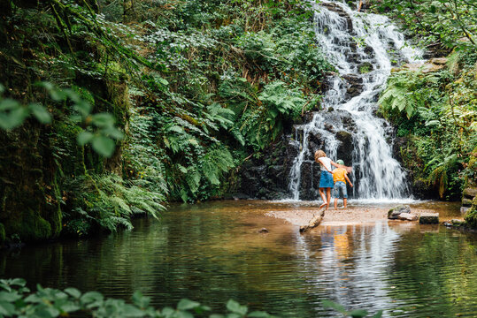 deux enfants jouant dans une cascade d'eau. Cascade de Faymont dans les Vosges. Chute d'eau en &eacute;t&eacute; dans la for&ecirc;t.