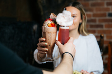 A woman is holding a glass of pink drink