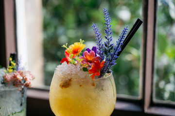 A glass of a drink with flowers on top