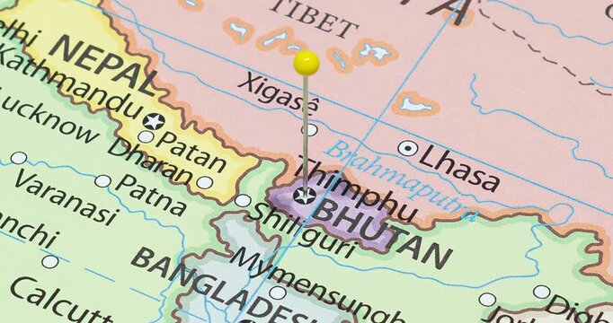 A zoom out of a yellow pin into thimphu city of bhutan political map