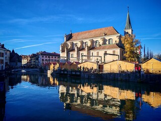 Obraz premium Annecy, France - November 29, 2025: Marche de Noel, christmas market with hot food, mulled wine, raclette and toys 