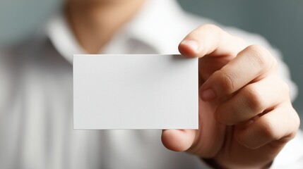 A crisp, professional close-up of a business man's hand extending forward, presenting a perfectly blank business card directly to the viewer.