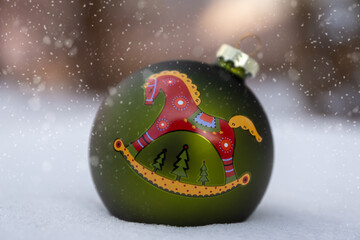 New Year 2026, a Christmas tree decoration lies in the snow.