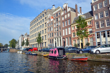 AMSTERDAM NETHERLANDS OCTOBER 03 2015: Typical canal boat Houses . Canal houses usually had a basement and a loft and attic where trade goods could be stored.