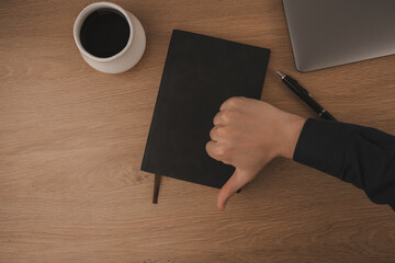 hand sing showing thumbs down, not happy to work, not good work life balance and working environment