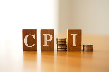 CPI inflation rate concept with wooden blocks and coins on table transparent background