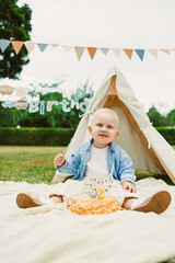 Celebrating a joyful second birthday with a sweet cake and decorations in a sunny outdoor setting
