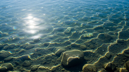 Clear lake with underwater light rays shining downward.