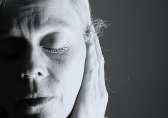 deaf woman suffering from deafness and hearing loss on gray background with people stock image stock photo	
