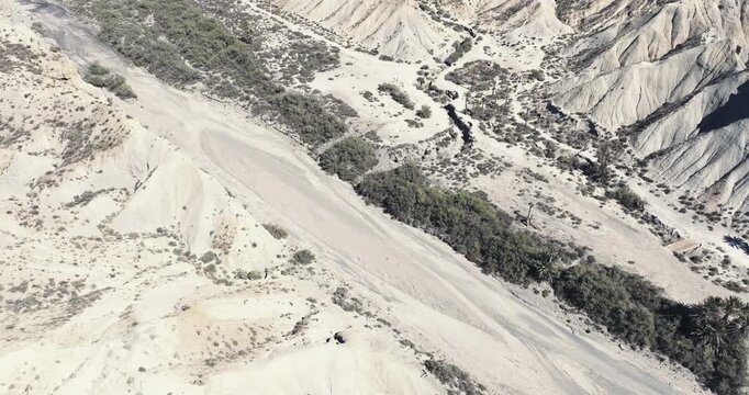 Top down aerial of eroded desert slopes and winding dry channels in the Tabernas Desert of Andalusia Spain, cinematic grading