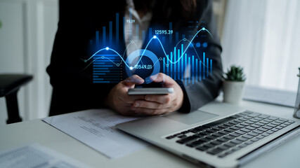 A business professional engages with financial data on a smartphone, surrounded by digital graphs and charts in a modern office setup, showcasing analytical insights. Scalp