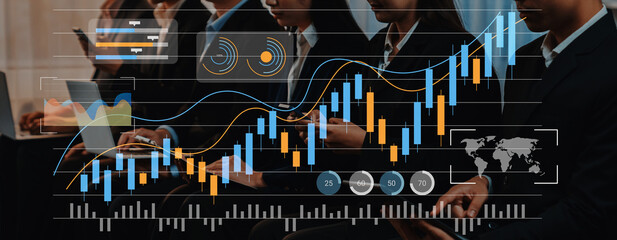 A dynamic scene of business professionals engaged in financial analysis using laptops, with stock market charts overlaying the image, showcasing modern analytics and strategic insights. Gantry