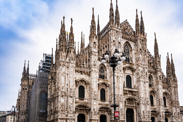 Fototapeta premium Duomo di Milano cathedral with Gothic spires and detailed marble façade under a bright blue sky.