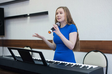 Caucasian woman singing into microphone. 