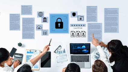 A business team collaborates on strategies for cybersecurity, reviewing documents and data on screens, emphasizing the importance of secure information management in today digital age. Gantry