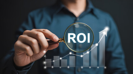 Financial analyst using magnifying glass to inspect ROI return on investment data and growth statistics.png