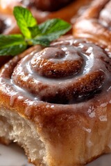 Cinnamon roll close up with sweet icing and fresh mint, symbolizing homemade breakfast pastry and dessert baking