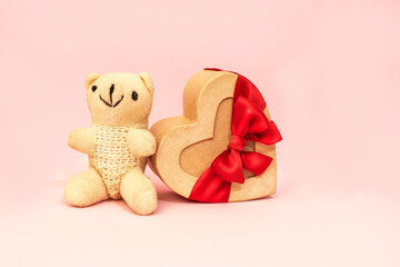 A romantic Valentine's Day gift card featuring a teddy bear, a heart-shaped box with a bow. Festive background. Invitation, congratulations