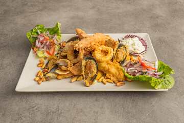 A northern-style chicken jalea, with chicken breasts fried until golden and crispy, topped with a sauce of onion, tomato, and chopped cilantro, accompanied by fried sweet potato © Toyakisfoto.photos
