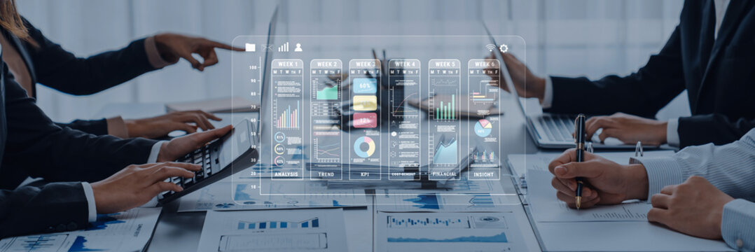 Modern business meeting focused on collaboration and technology integration, showcasing data visualization and teamwork in a sleek office environment. Trope - Powered by Adobe