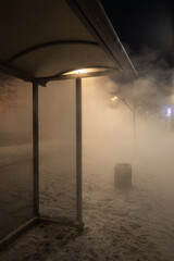 Night scene of a central heating pipe burst on Bucharest Street in Saint Petersburg, with steam, snow, and empty urban bus stop.