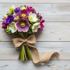 Beautiful bouquet of colorful flowers tied with burlap ribbon on wooden background