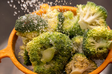 Frischer Bio Broccoli mit Wasser vor dem Kochen waschen