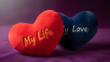 Two plush heart-shaped cushions one red embroidered with my life and one blue with my love rest upon a soft purple surface