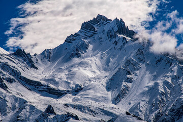 Tilicho Peak and surrounding alpine ridges near Muktinath, Nepal. Dramatic Himalayan mountain scene with sharp rock formations, snow-covered slopes, and deep blue sky, 