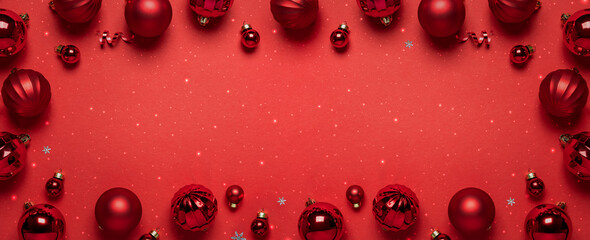 Frame of Christmas red decorations on red background with light and bokeh. Merry Christmas and Happy New Year greeting card. Xmas and Winter holidays. Christmas background, top view