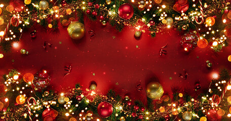 Christmas tree branches with red glitter decorations on red background with bokeh. Merry Christmas and Happy New Year greeting card. Xmas and Winter holidays. Christmas time, top view