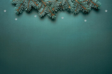 Christmas fir branches on blue background with snowflakes. Merry Christmas and Happy New Year greeting card. Xmas and winter holidays. Christmas banner, top view