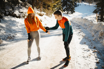 A happy young couple laughing and having fun while warming up for a winter run on a snowy day