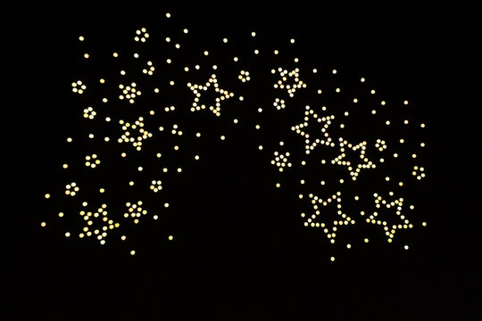 Golden Stars and Sparkling Lights Image Created by UAV Drone Light Show with Soft Focus and Minimal Bokeh Effect