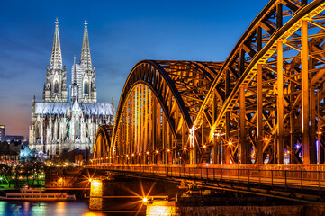 Obraz premium Hohenzollern Bridge and Cologne Cathedral at dusk, in Koln, Germany.