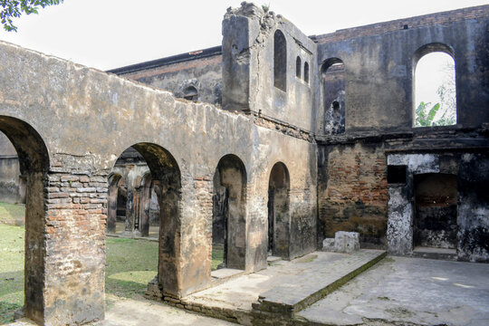 a view of the dilapidated and weathered brick ruins of the historic "jamindar" estate, featuring traditional bengal colonial-style architecture in the heritage village of pathra