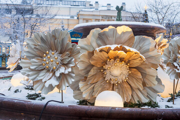 Moscow, Russia, 29 December 2025  Large decorative winter flowers with snow and warm lighting installation in a city square.
