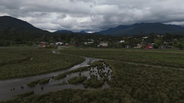 Aerial View of Valley with River Deltas Rural Village and Dramatic Cloudscape