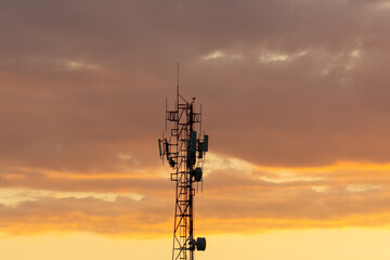 Silhouette of telecommunication tower at sunset with beautiful sky.