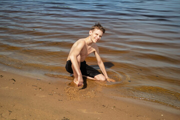 Boy Playing with Sand by the Waterside