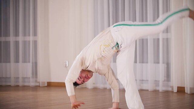 Martial arts. Capoeira. A professional man performs a turnovers leaning on hands
