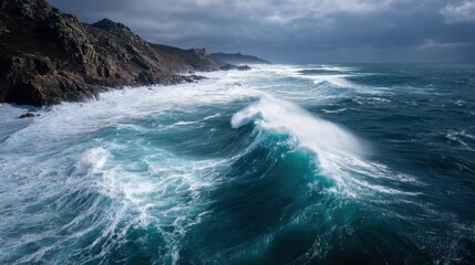 Waves rise and crash onto the rocky shoreline as dark clouds gather overhead. The scene shows a wild ocean near cliffs at dusk creating a dynamic coastal view.