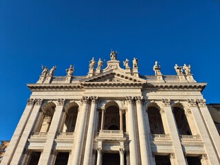Rome, Italy - 14 January 2025. The Basilica of San Giovanni in Laterano stands with a grand symmetrical facade, statues of saints, and towering columns beneath a clear sky
