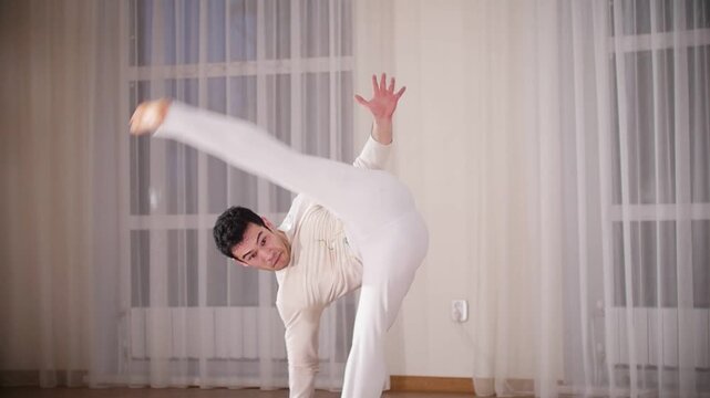 Martial arts. Capoeira. A professional acrobatic man performs a capoeira movements. Turn overs in the air