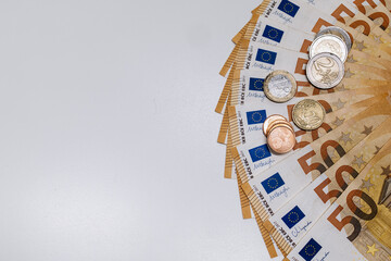 Euro banknotes and coins arranged in a circular pattern on a clean surface, showcasing currency details and textures, ideal for financial concepts and economic themes