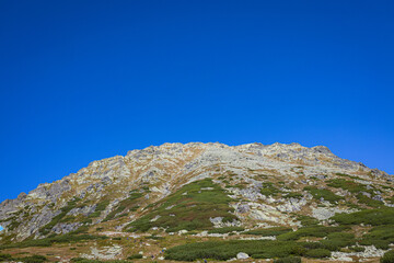 Kozi Wierch peak rising above alpine slopes in in Valley of Five Polish Ponds, Tatra Mountains