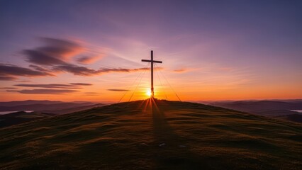 Silhouette of a cross on a mountain peak against a vivid sunset backdrop