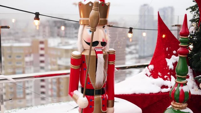 Outdoor terrace with large nutcrackers, festive decorations and decorated Christmas tree with toys balls and red stars. Beautiful interior balcony of the house on holiday winter and New Year. 