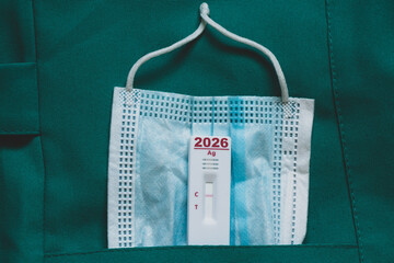 A rapid viral test with a medical mask in a doctor's coat pocket and the number 2026, a symbol of healthcare, diagnostics, prevention, and health protection
