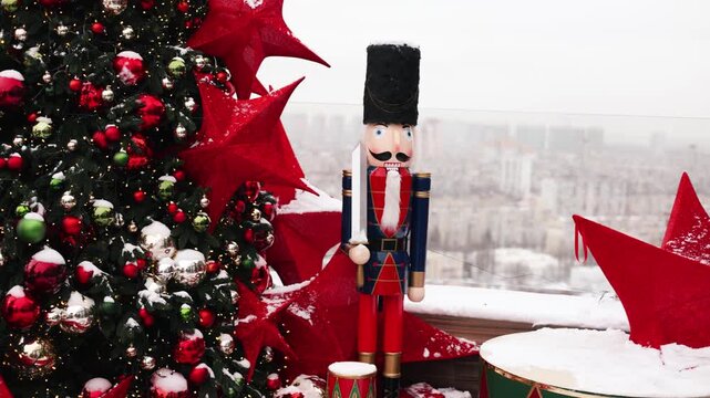 Outdoor terrace with large nutcrackers, festive decorations and decorated Christmas tree with toys balls and red stars. Beautiful interior balcony of the house on holiday winter and New Year. 